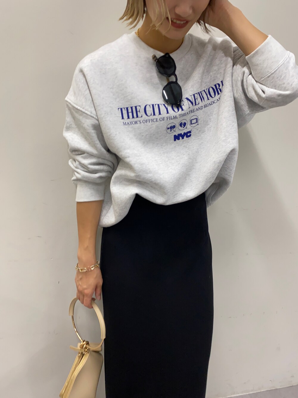 グレー系のスウェット、ブラック系のスカートを着用したレディースの秋コーディネートの2枚目の写真