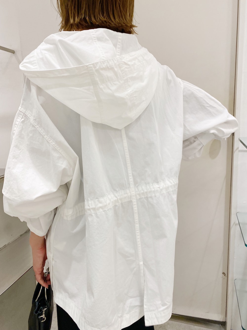 ブラック系のワンピース、ホワイト系のモッズコートを着用したレディースの春コーディネートの3枚目の写真