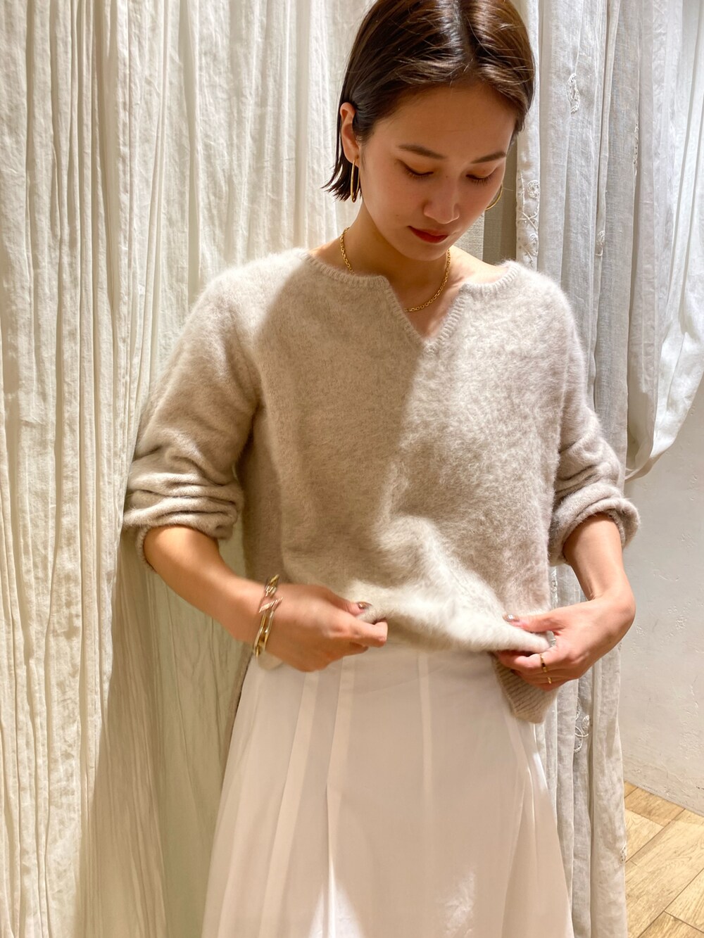 ホワイト系のニット/セーターを着用したレディースの冬コーディネートの2枚目の写真