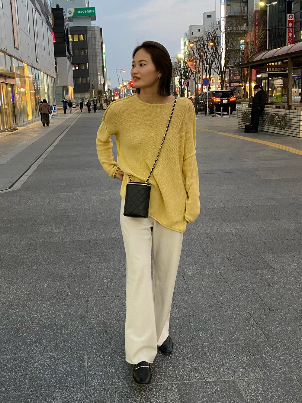 イエロー系のニット/セーター、グレー系のその他パンツを着用したレディースの冬コーディネートの2枚目の写真