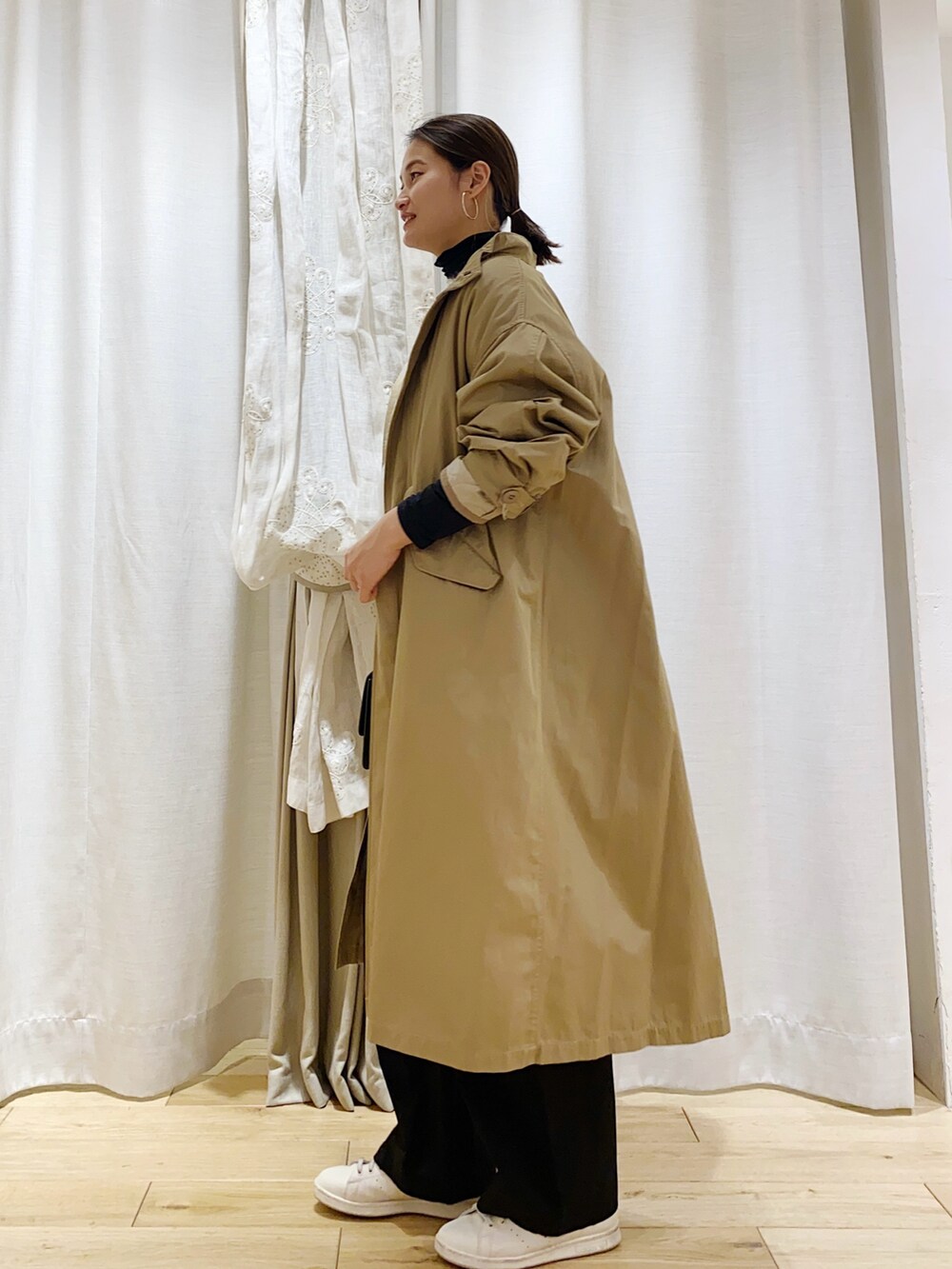 ベージュ系のモッズコートを着用したレディースの冬コーディネートの2枚目の写真