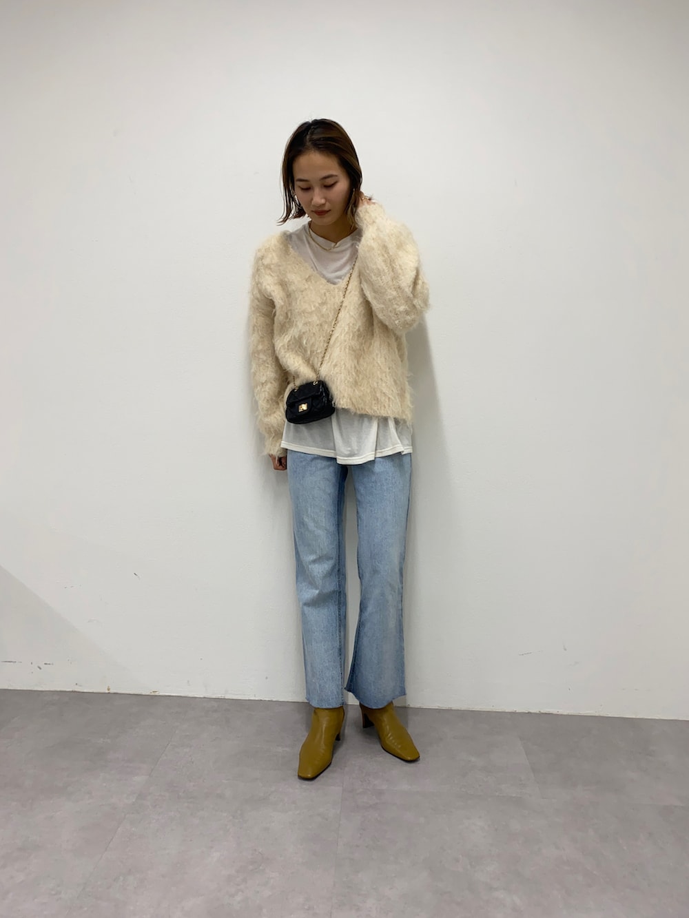 ブルー系のデニムパンツを着用したレディースの秋コーディネートの3枚目の写真