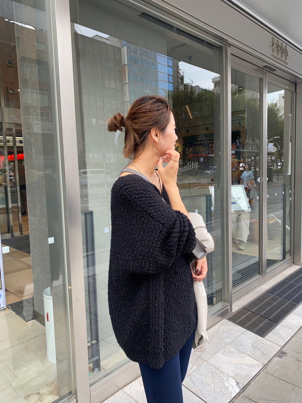 ブラック系のニット/セーターを着用したレディースの秋コーディネートの2枚目の写真