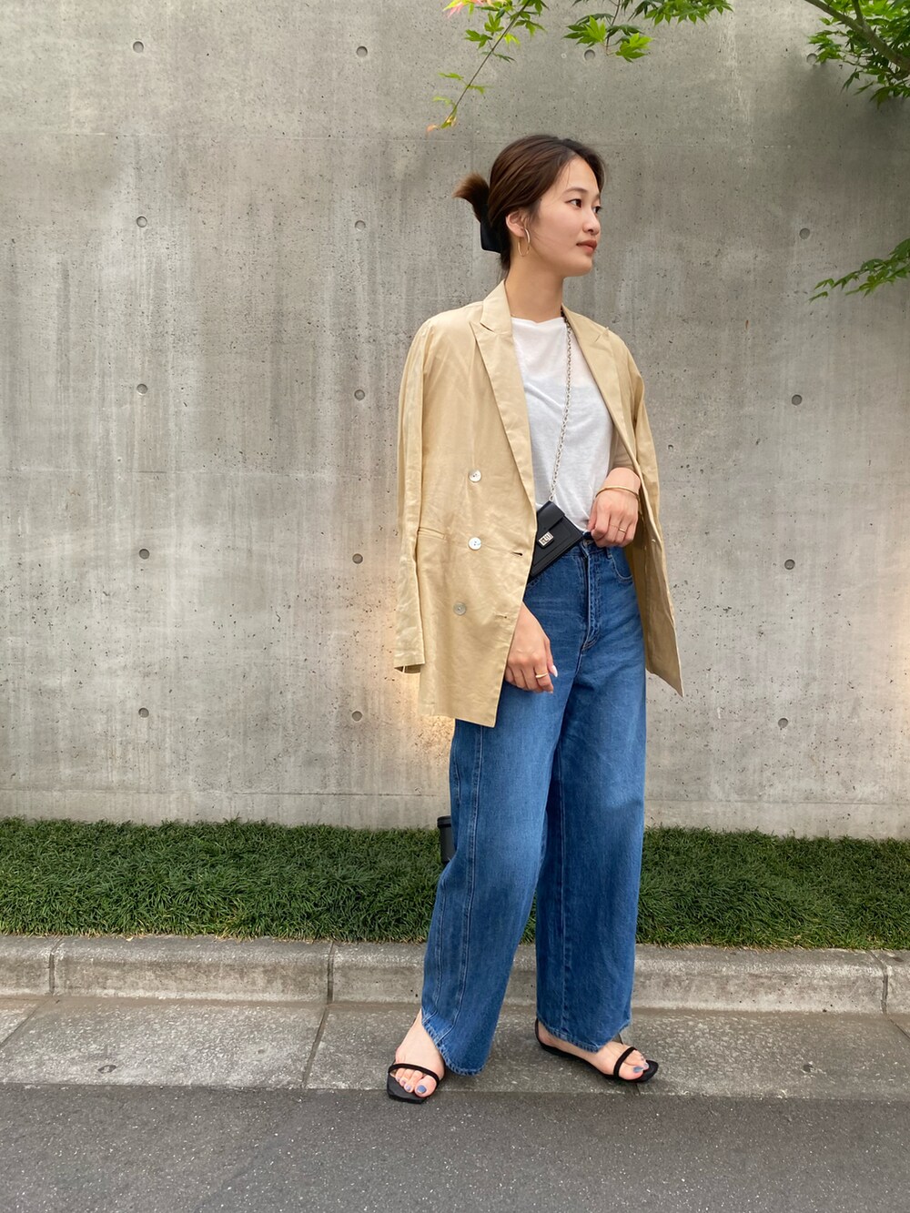 ホワイト系のTシャツ/カットソー、ベージュ系のテーラードジャケット、ブルー系のデニムパンツを着用したレディースの春コーディネートの3枚目の写真