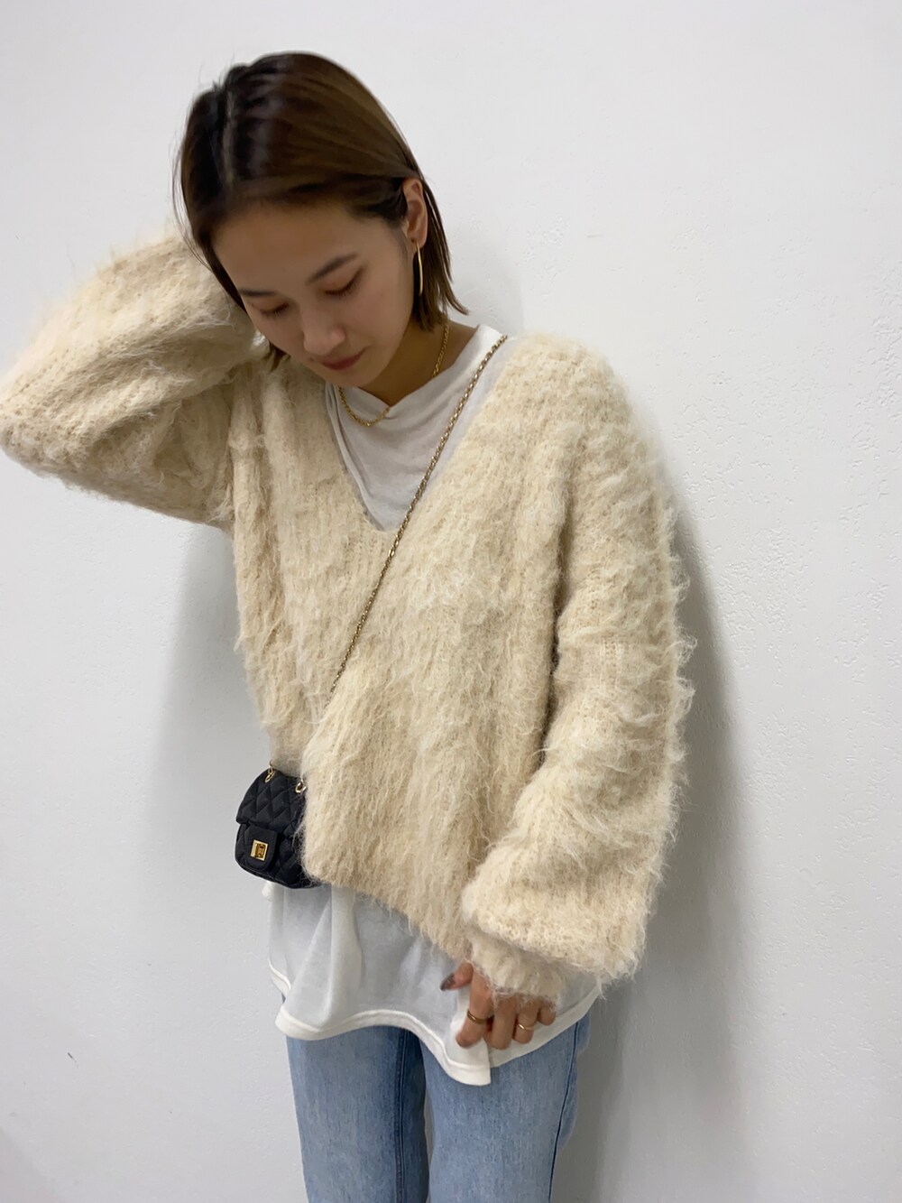 ブルー系のデニムパンツを着用したレディースの秋コーディネートの2枚目の写真