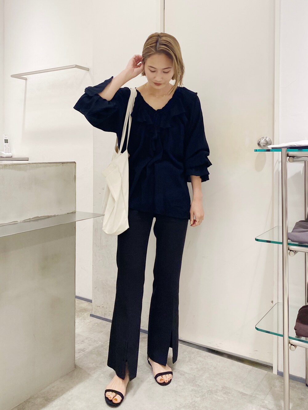 ブラック系のシャツ/ブラウスを着用したレディースの春コーディネートの2枚目の写真