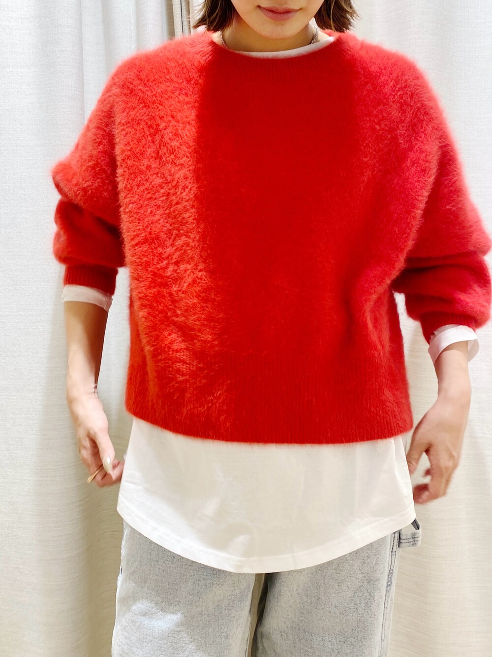 レッド系のトップスを着用したレディースの冬コーディネートの2枚目の写真