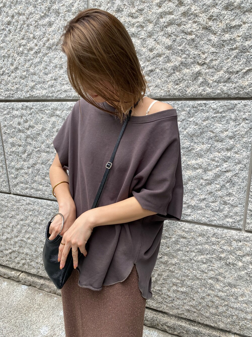 ブラウン系のスカート、ホワイト系のスウェットを着用したレディースの夏コーディネートの2枚目の写真