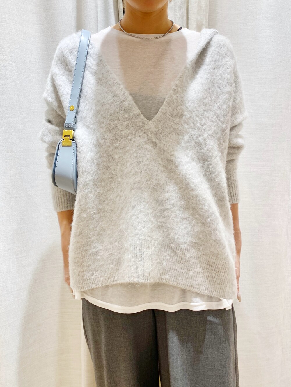 グレー系のスラックス、グレー系のニット/セーターを着用したレディースの秋コーディネートの3枚目の写真