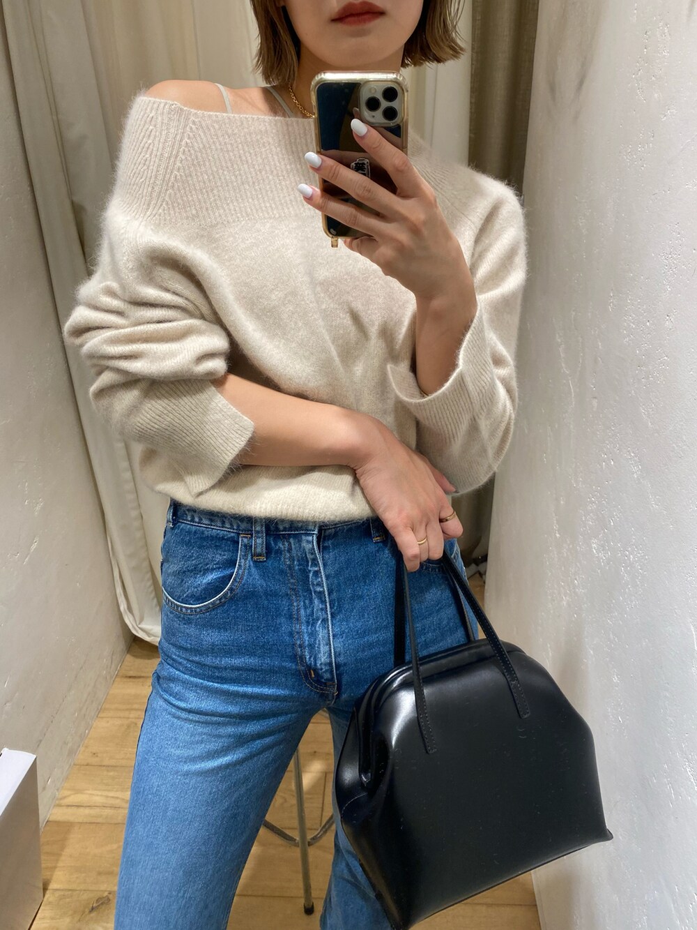 ブルー系のデニムパンツ、ベージュ系のニット/セーターを着用したレディースの秋コーディネートの2枚目の写真