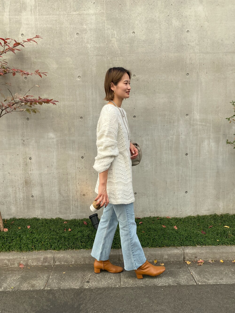 ブルー系のデニムパンツを着用したレディースの秋コーディネートの2枚目の写真