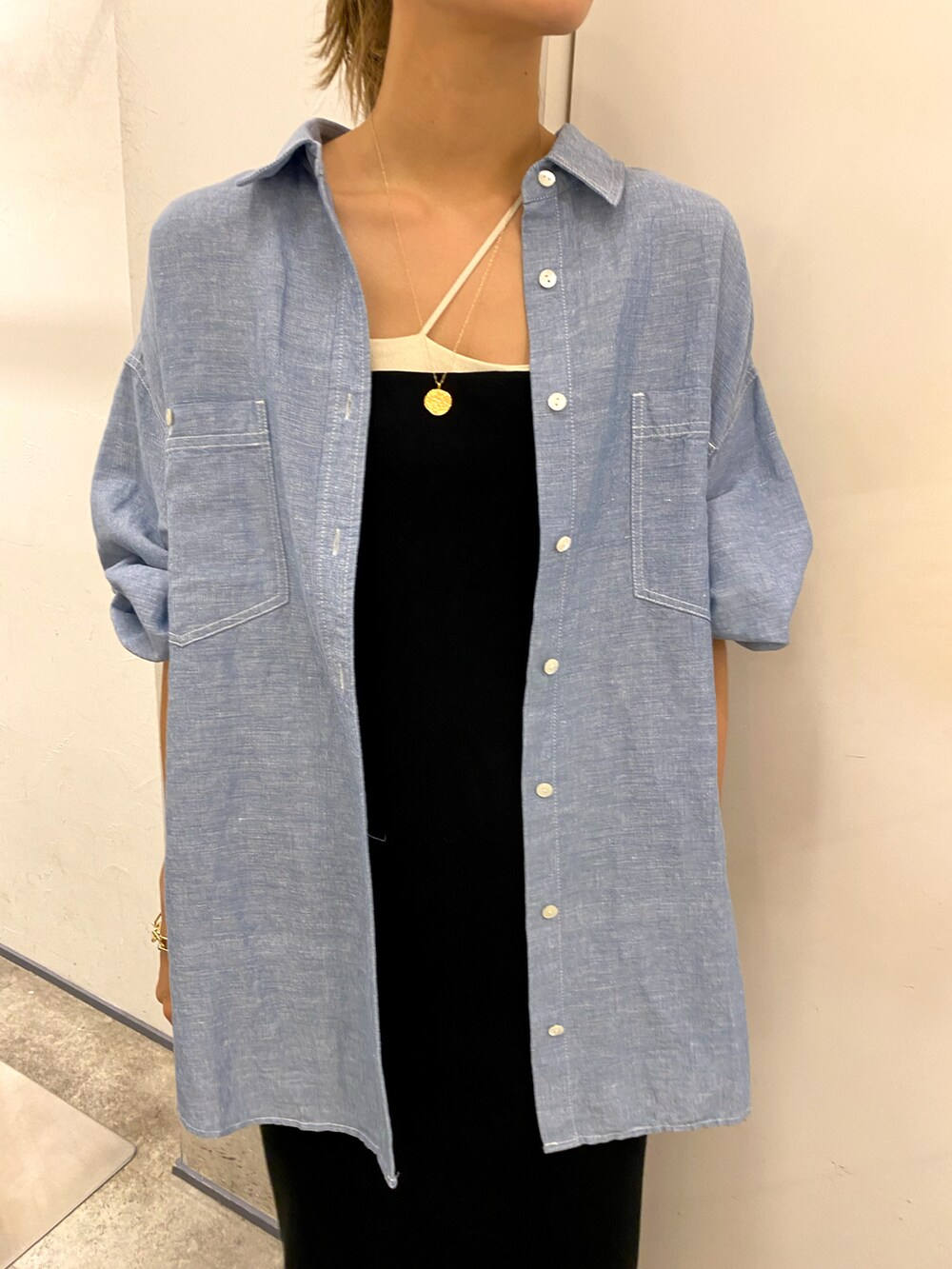 ブラック系のワンピース、ブルー系のシャツ/ブラウスを着用したレディースの夏コーディネートの2枚目の写真