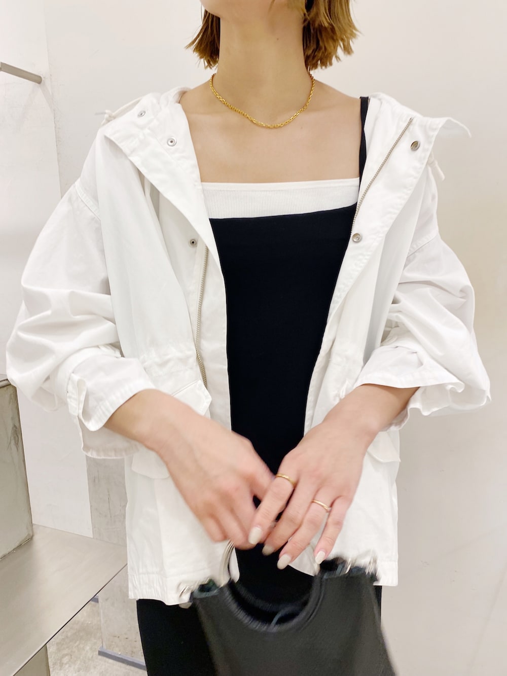 ブラック系のワンピース、ホワイト系のモッズコートを着用したレディースの春コーディネートの2枚目の写真