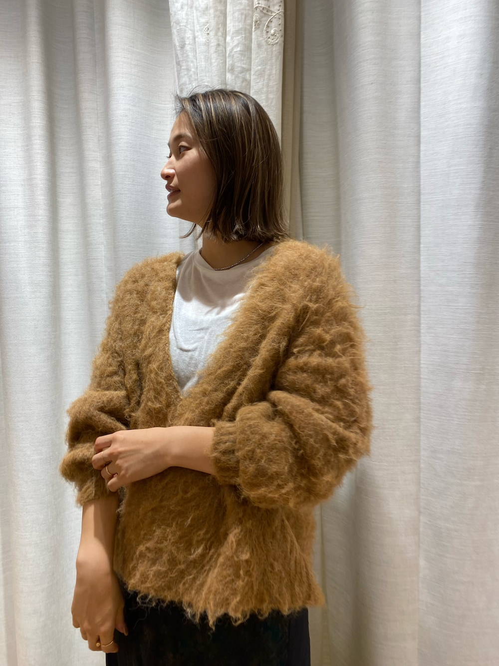 ホワイト系のニット/セーターを着用したレディースの冬コーディネートの2枚目の写真