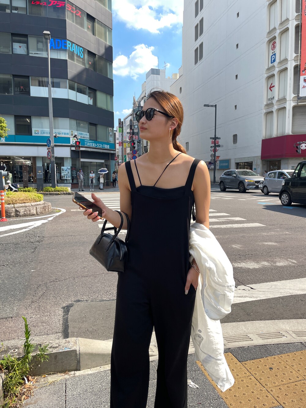 ブラック系のサロペット/オーバーオール、ホワイト系のミリタリージャケットを着用したレディースの夏コーディネートの3枚目の写真