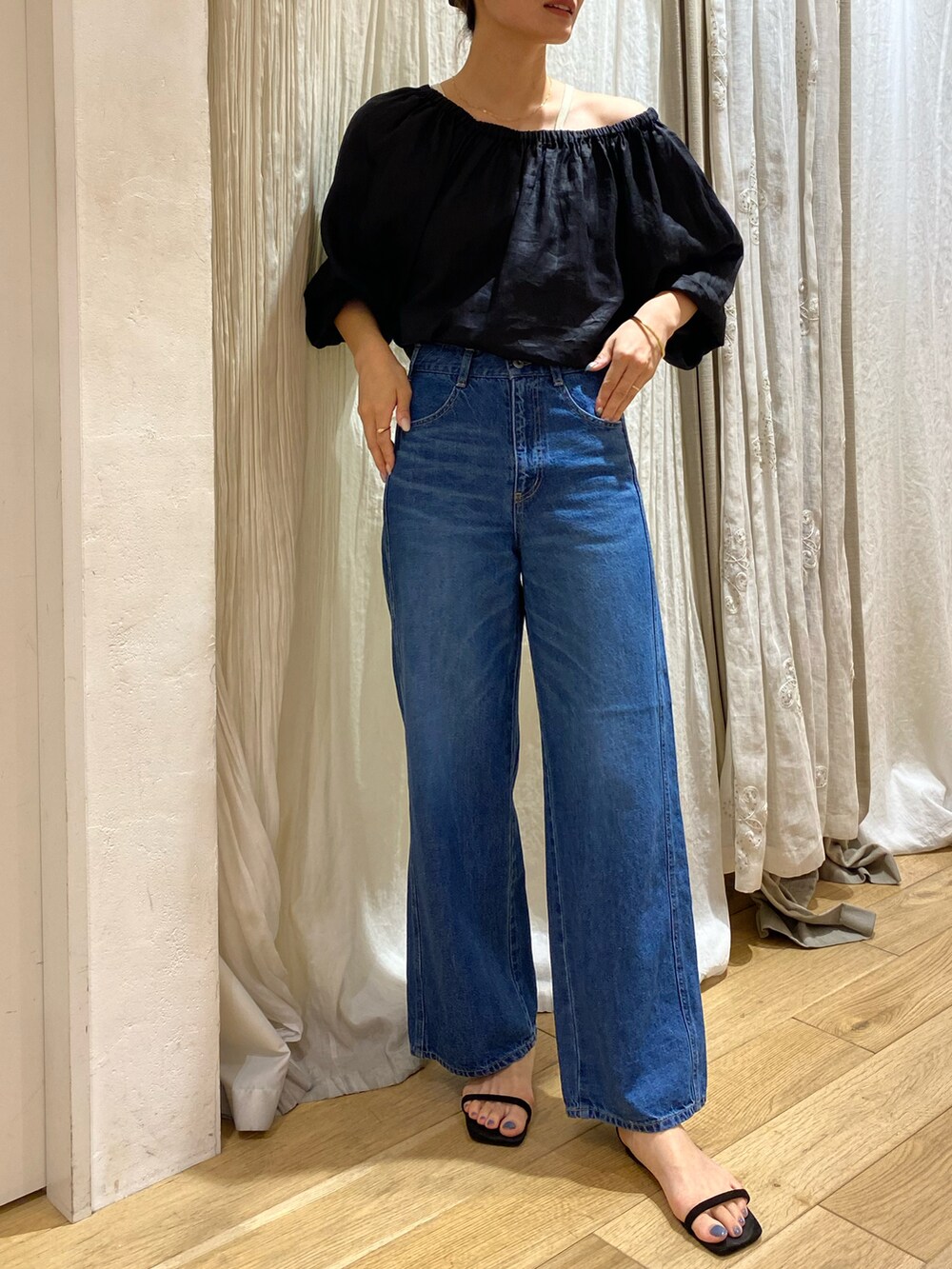 ブラック系のシャツ/ブラウス、ブルー系のデニムパンツを着用したレディースの春コーディネートの2枚目の写真
