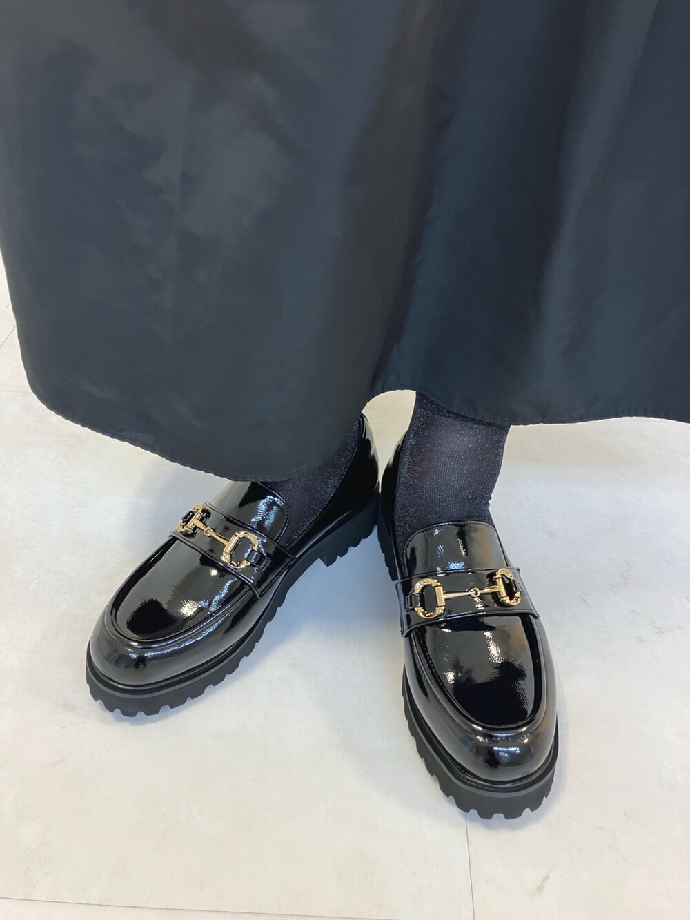 ブラック系のレインシューズを着用したレディースの秋コーディネートの3枚目の写真