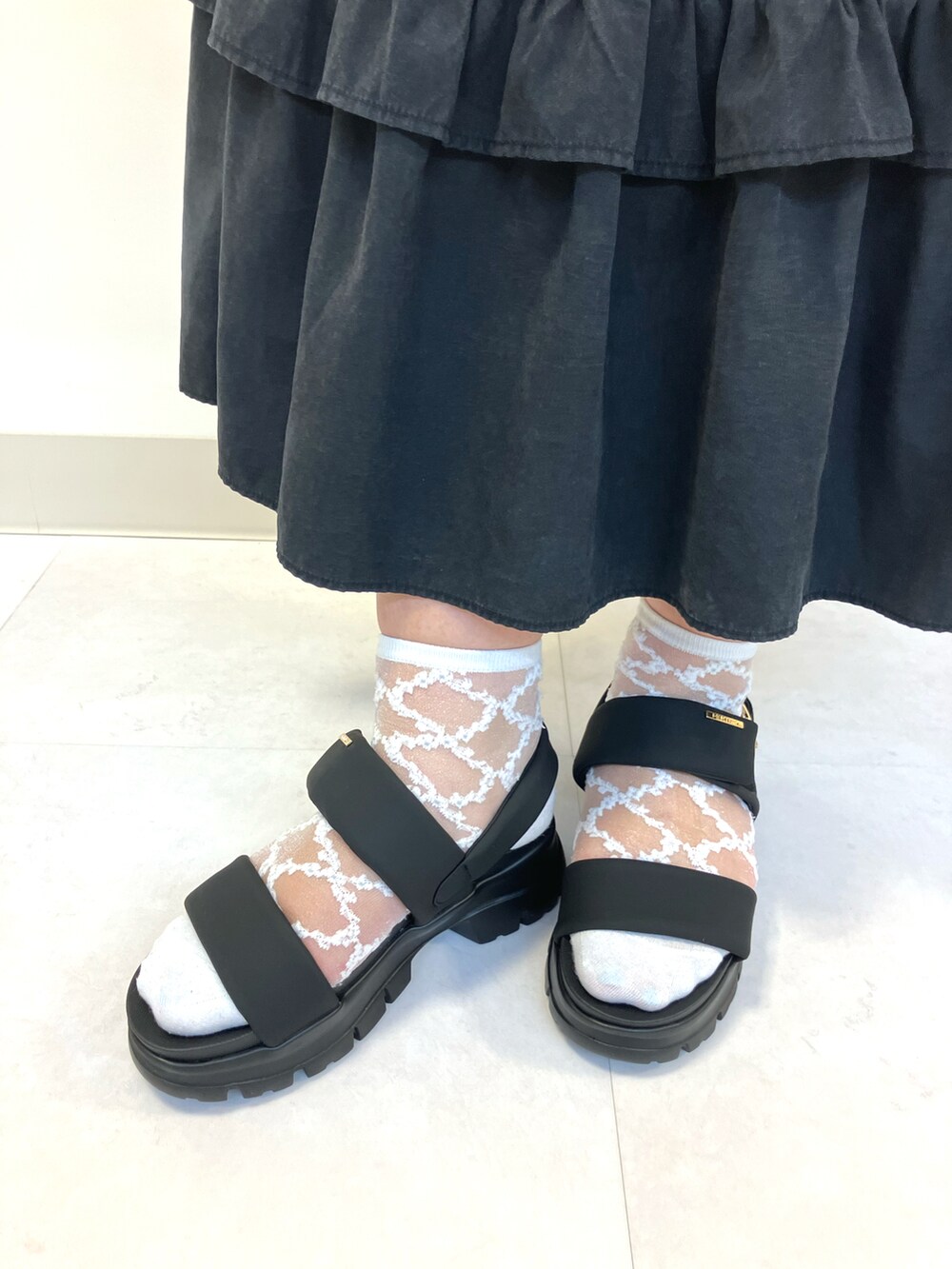 ブラック系のサンダルを着用したレディースの夏コーディネートの2枚目の写真