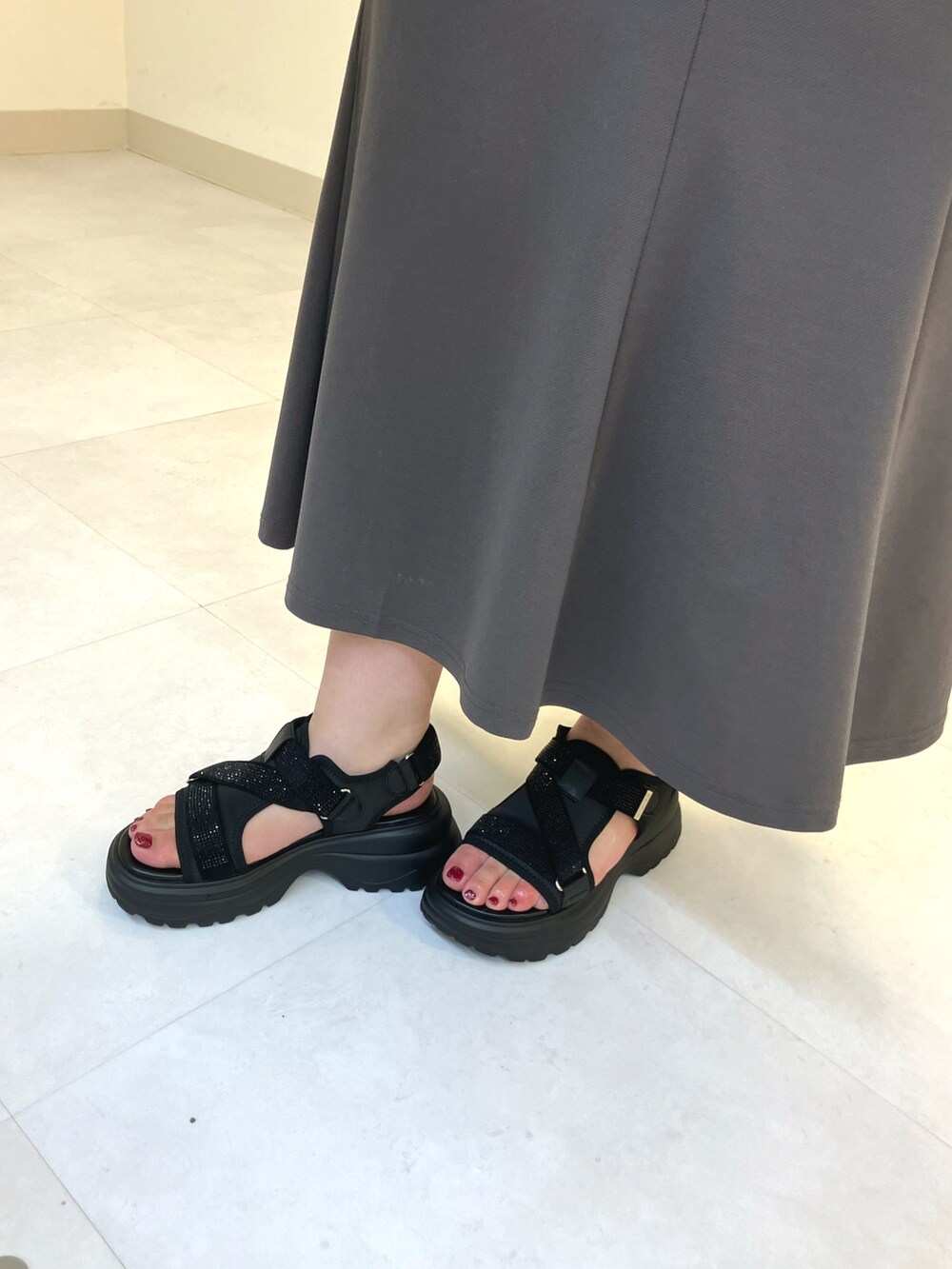 ブラック系のサンダル、ブラック系のショルダーバッグを着用したレディースの春コーディネートの2枚目の写真