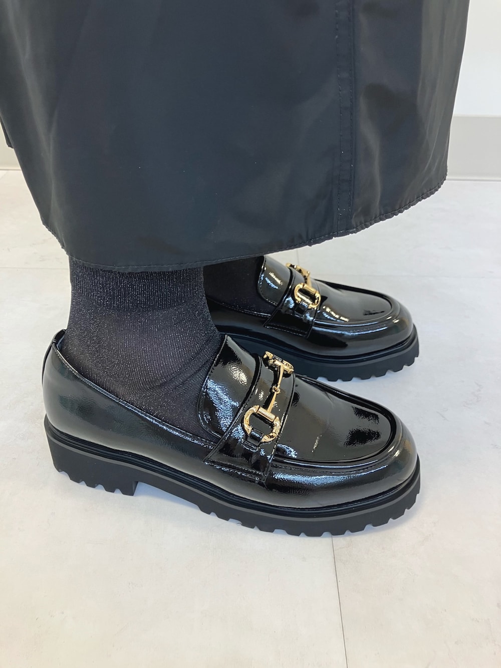 ブラック系のレインシューズを着用したレディースの秋コーディネートの2枚目の写真