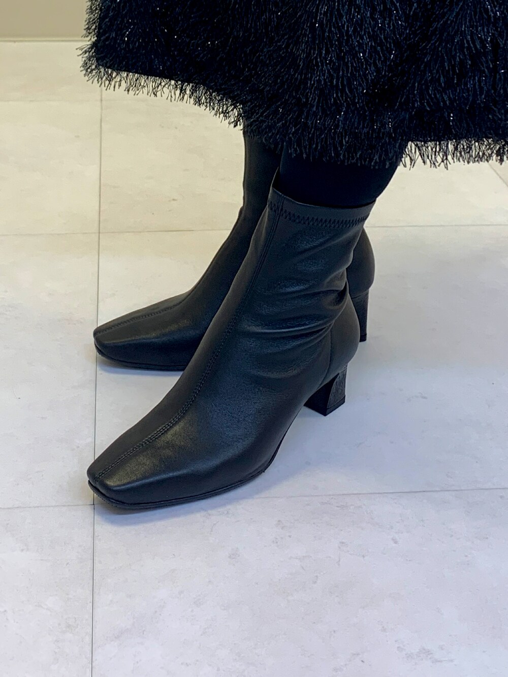 ブラック系のブーツを着用したレディースの秋コーディネートの2枚目の写真