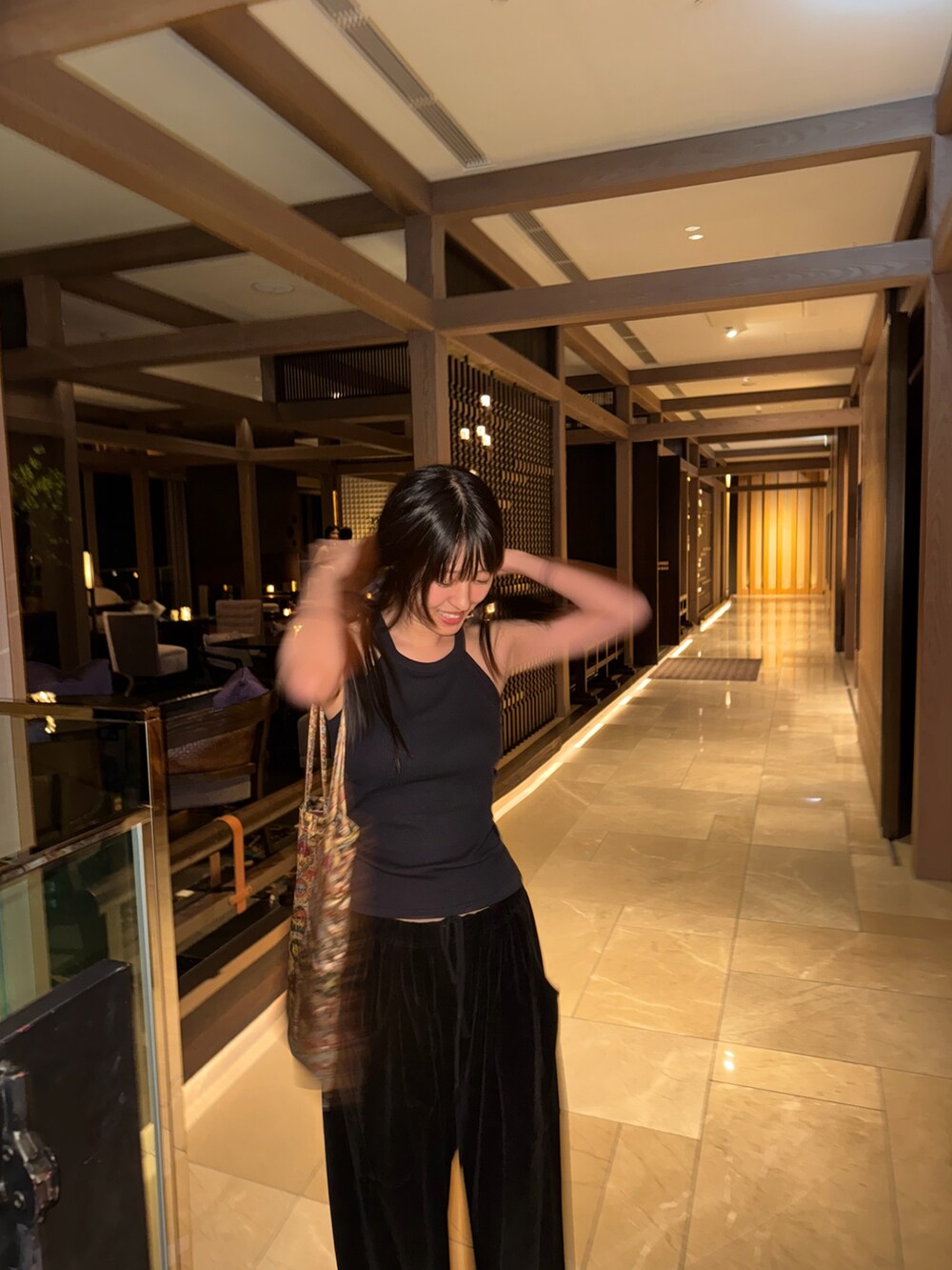 ブラック系のトップスを着用したレディースの夏コーディネートの3枚目の写真