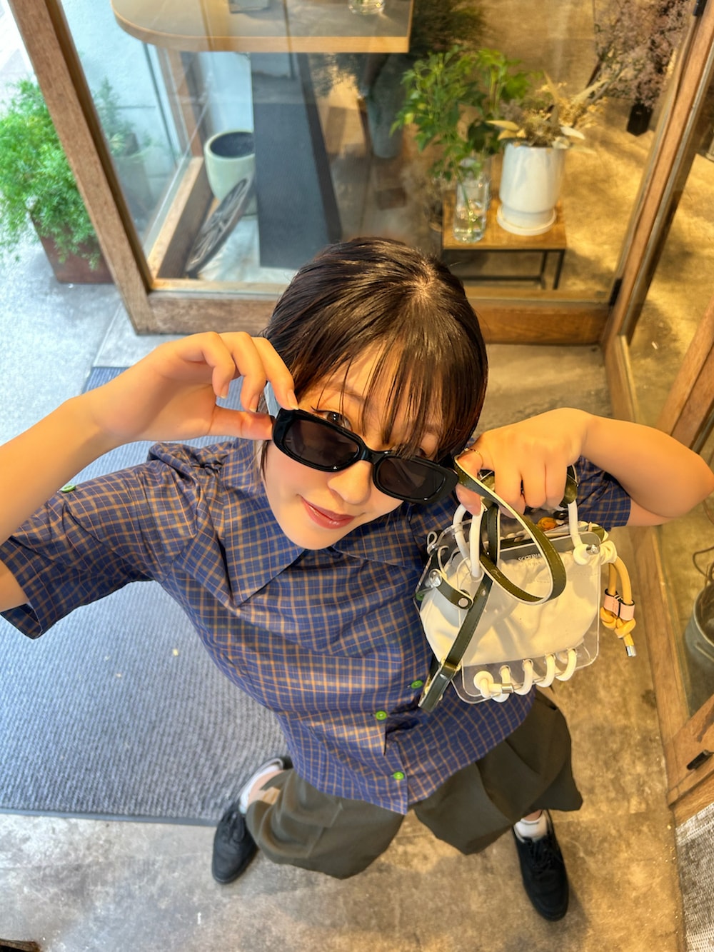 ブルー系のトップスを着用したレディースの夏コーディネートの2枚目の写真