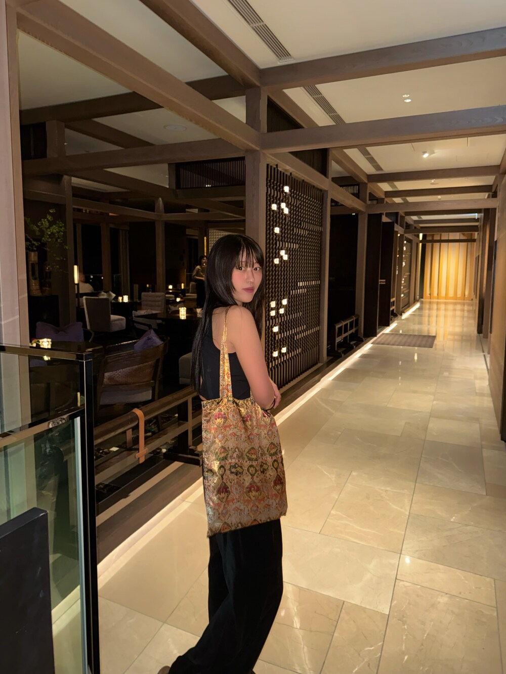 ブラック系のトップスを着用したレディースの夏コーディネートの2枚目の写真