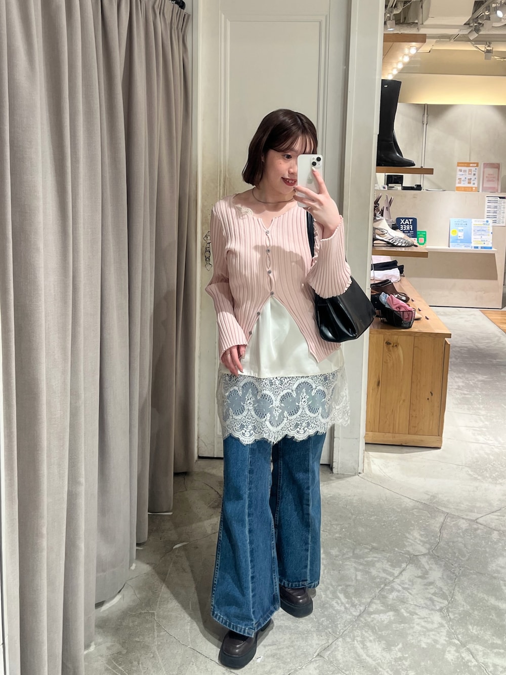 ピンク系のカーディガン/ボレロ、ホワイト系のシャツ/ブラウス、ブルー系のデニムパンツを着用したレディースの冬コーディネートの2枚目の写真