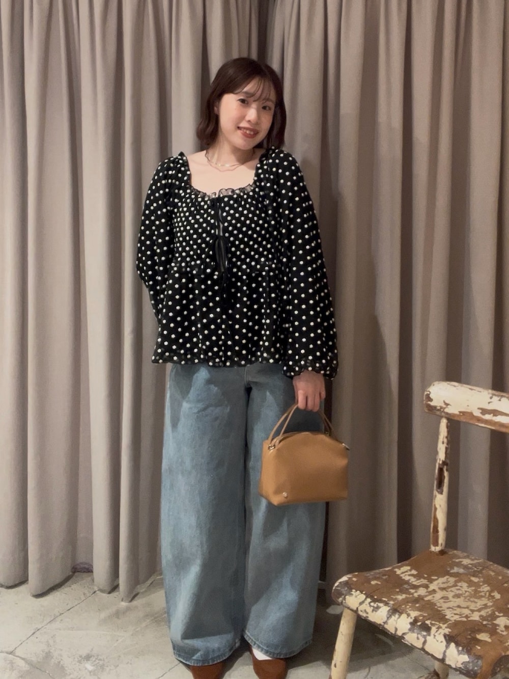 ブラック系のシャツ/ブラウス、ブルー系のデニムパンツ、イエロー系のハンドバッグを着用したレディースの冬コーディネートの2枚目の写真