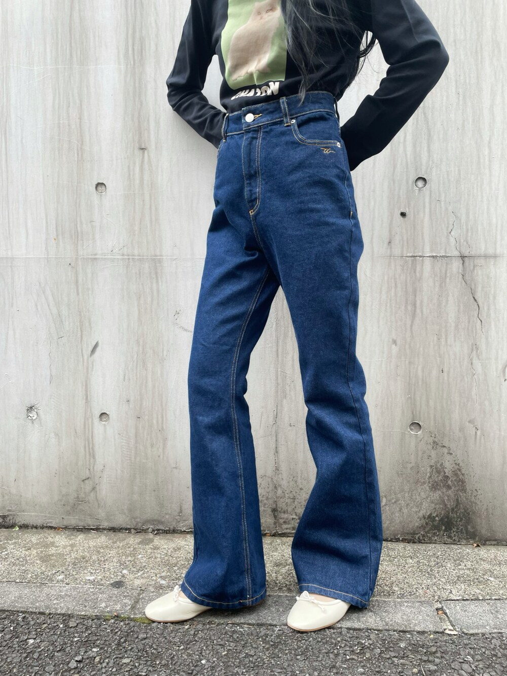 ブルー系のデニムパンツ、ブラック系のTシャツ/カットソー、ホワイト系のバレエシューズを着用したレディースの秋コーディネートの2枚目の写真