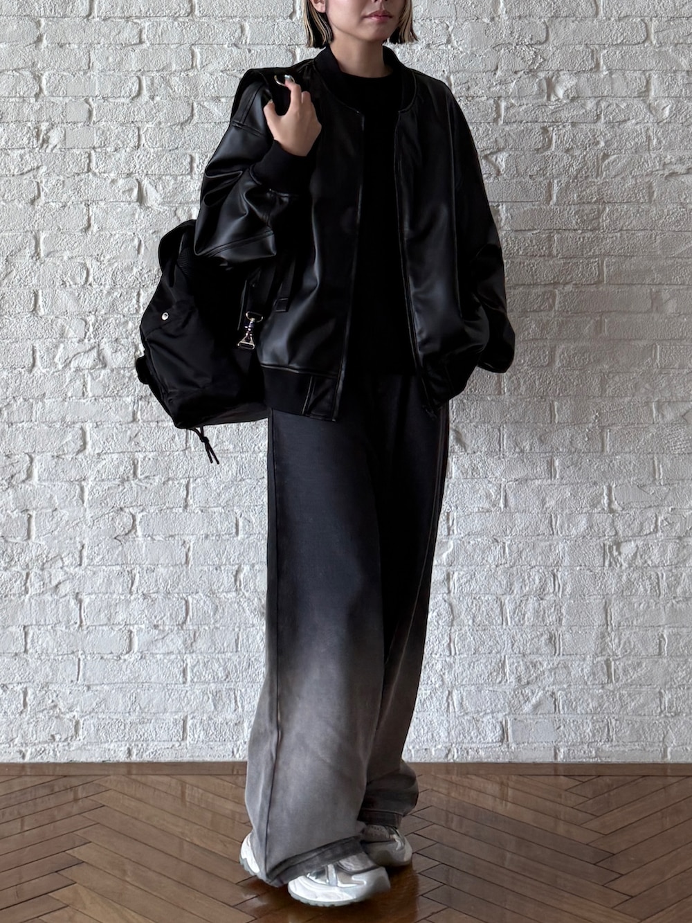 ブラック系のバックパック/リュック、ブラック系のブルゾン、ブラック系のデニムパンツを着用したレディースの夏コーディネートの3枚目の写真