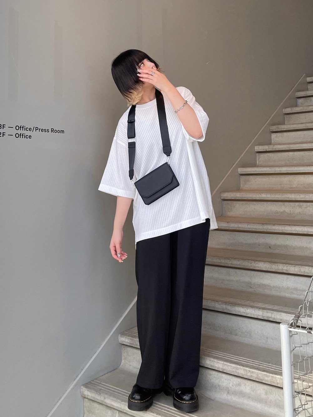 ブラック系のショルダーバッグを着用したレディースの春コーディネートの2枚目の写真