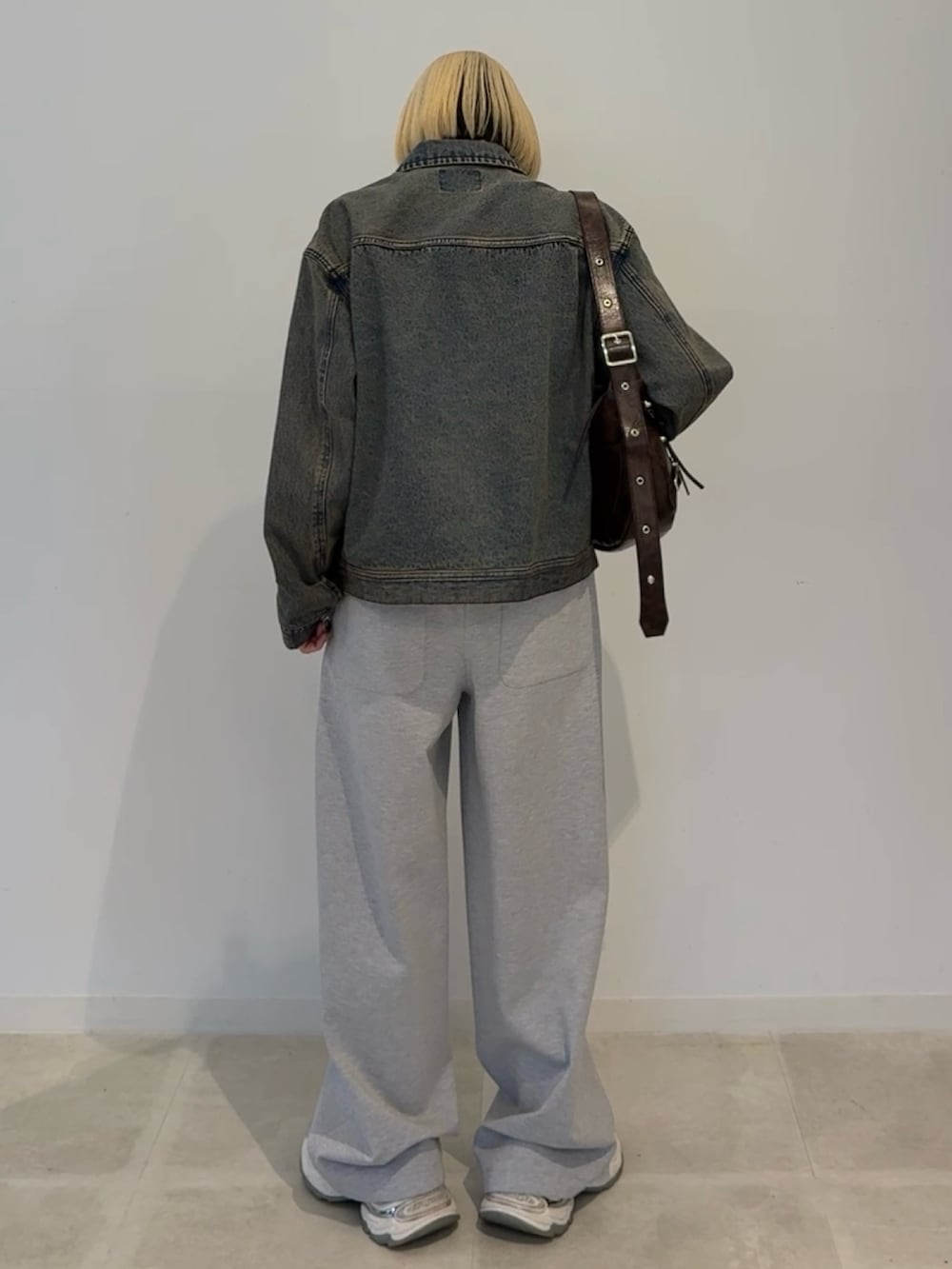 ブルー系のデニムジャケット、ブラウン系のショルダーバッグを着用したレディースの夏コーディネートの3枚目の写真