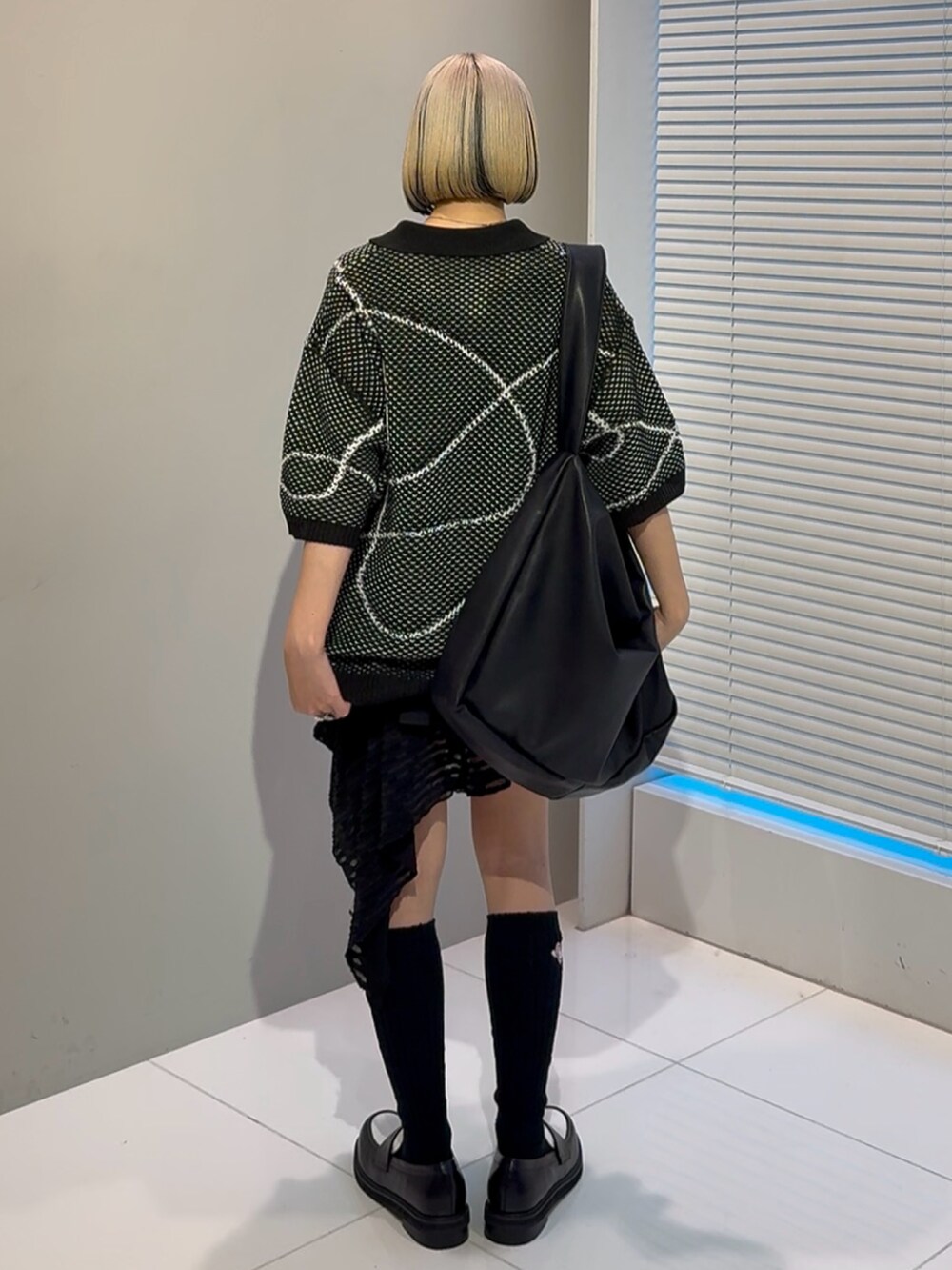 ブラック系のニット/セーター、ブラック系のショルダーバッグ、ブラック系のその他シューズを着用したレディースの春コーディネートの5枚目の写真