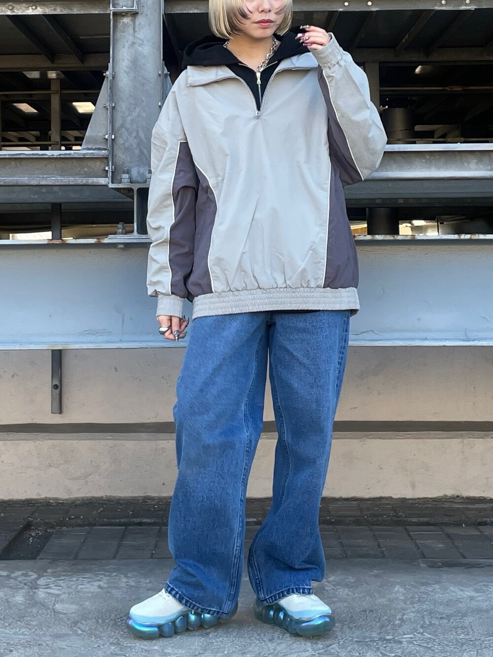 ブラック系のパーカー、グレー系のブルゾン、ブルー系のデニムパンツを着用したレディースの冬コーディネートの3枚目の写真