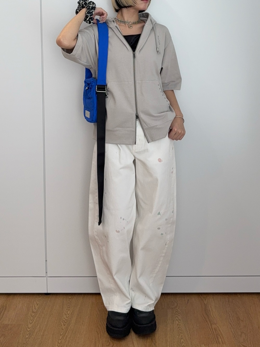 グレー系のパーカー、ブルー系のショルダーバッグ、ホワイト系のその他パンツを着用したレディースの夏コーディネートの4枚目の写真