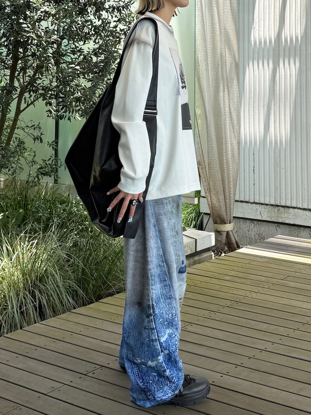 ホワイト系のTシャツ/カットソー、ブルー系のデニムパンツ、ブラック系のショルダーバッグを着用したレディースの夏コーディネートの3枚目の写真