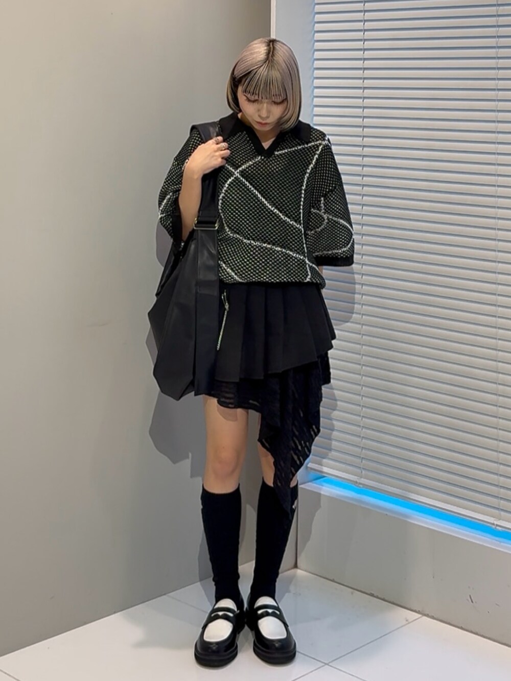 ブラック系のニット/セーター、ブラック系のショルダーバッグ、ブラック系のその他シューズを着用したレディースの春コーディネートの4枚目の写真