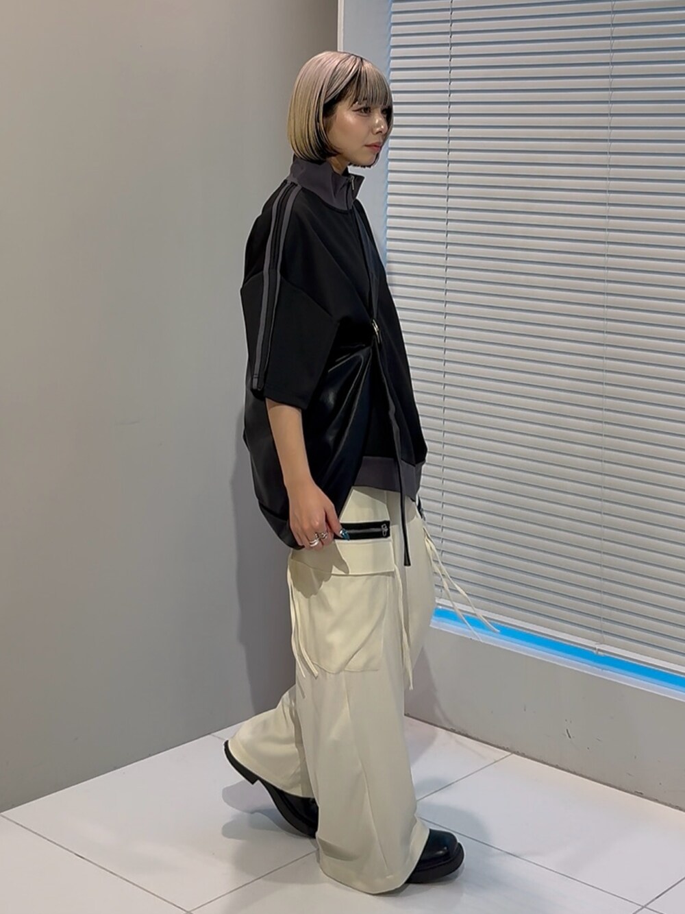 ブラック系のTシャツ/カットソー、ブラック系のショルダーバッグ、ホワイト系のカーゴパンツを着用したレディースの春コーディネートの2枚目の写真