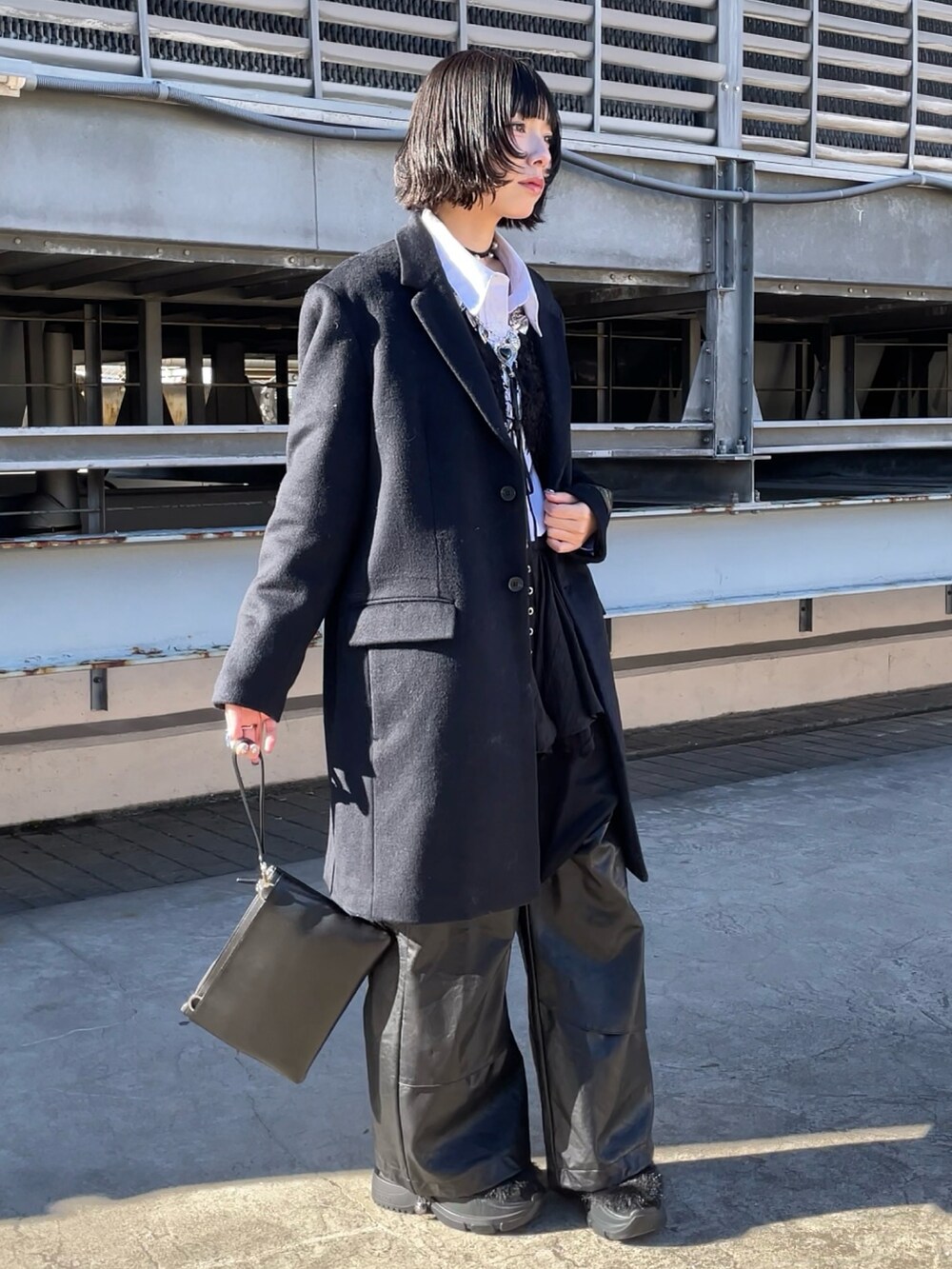 ブラック系のチェスターコート、ブラック系のショルダーバッグ、ブラック系のショルダーバッグを着用したレディースの冬コーディネートの2枚目の写真