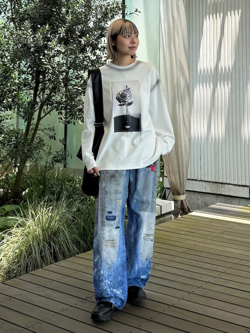 ホワイト系のTシャツ/カットソー、ブルー系のデニムパンツ、ブラック系のショルダーバッグを着用したレディースの夏コーディネートの2枚目の写真