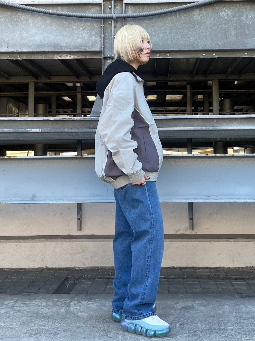 ブラック系のパーカー、グレー系のブルゾン、ブルー系のデニムパンツを着用したレディースの冬コーディネートの2枚目の写真