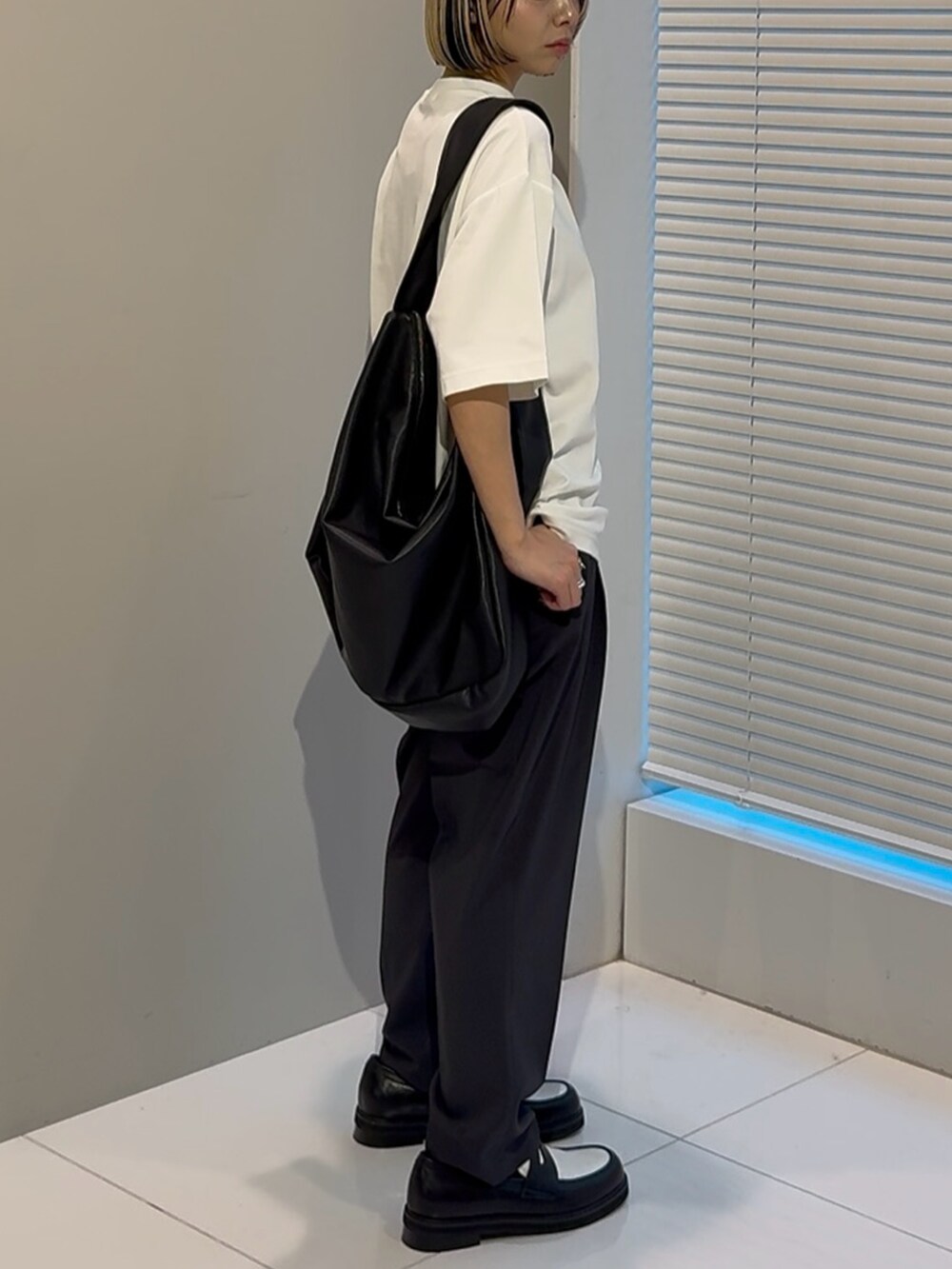 ホワイト系のTシャツ/カットソー、ブラック系のショルダーバッグ、ブラック系のその他シューズを着用したレディースの春コーディネートの2枚目の写真