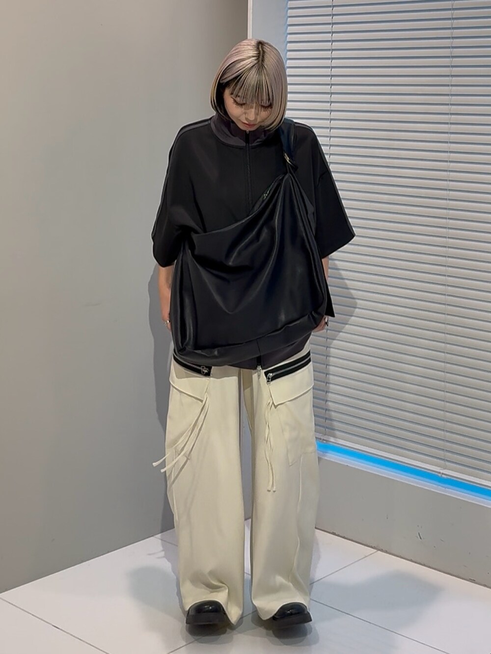 ブラック系のTシャツ/カットソー、ブラック系のショルダーバッグ、ホワイト系のカーゴパンツを着用したレディースの春コーディネートの3枚目の写真