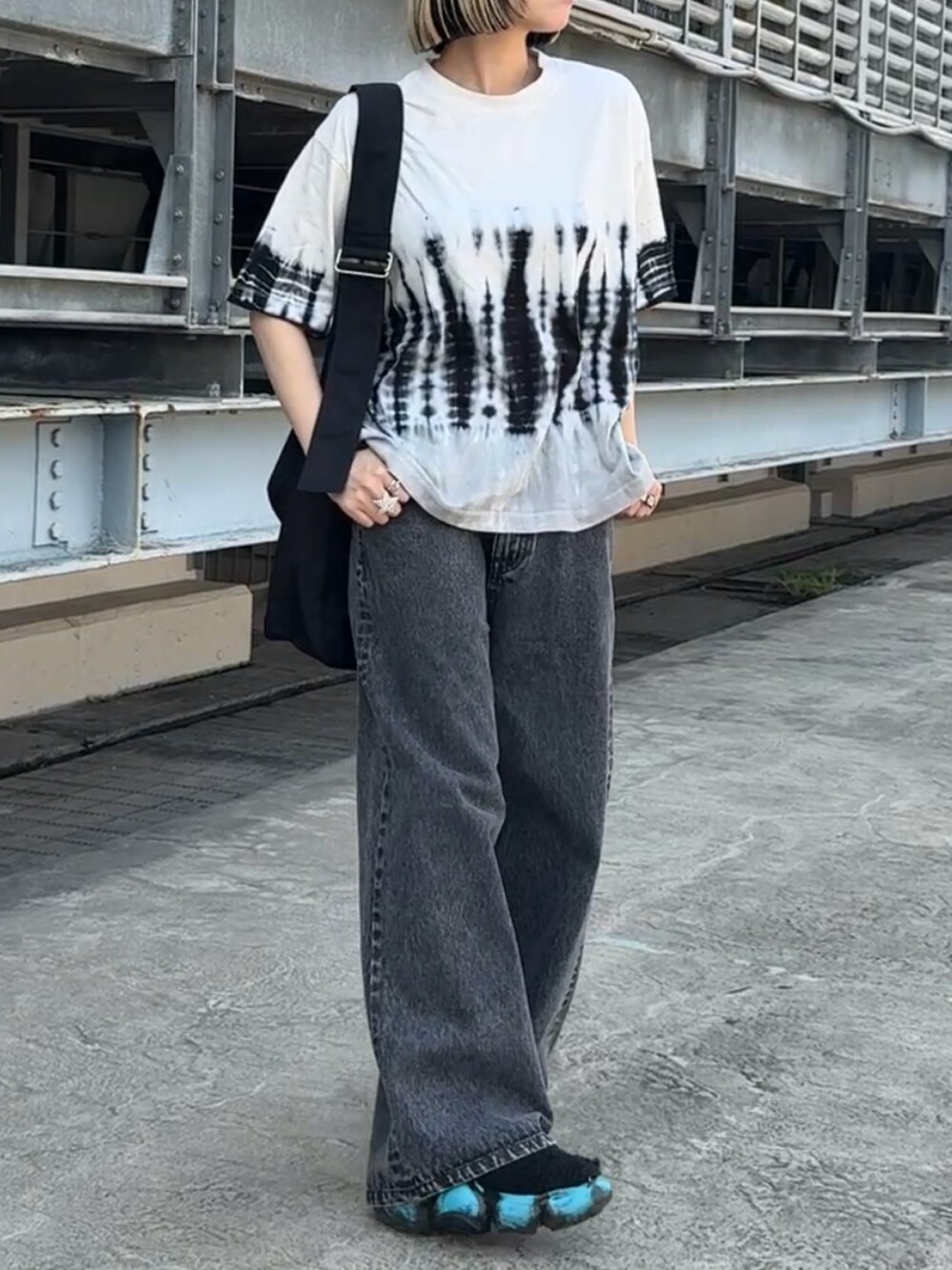 ホワイト系のTシャツ/カットソー、ブラック系のショルダーバッグ、ブラック系のデニムパンツを着用したレディースの夏コーディネートの3枚目の写真