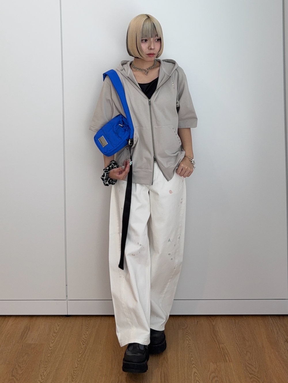 グレー系のパーカー、ブルー系のショルダーバッグ、ホワイト系のその他パンツを着用したレディースの夏コーディネートの3枚目の写真