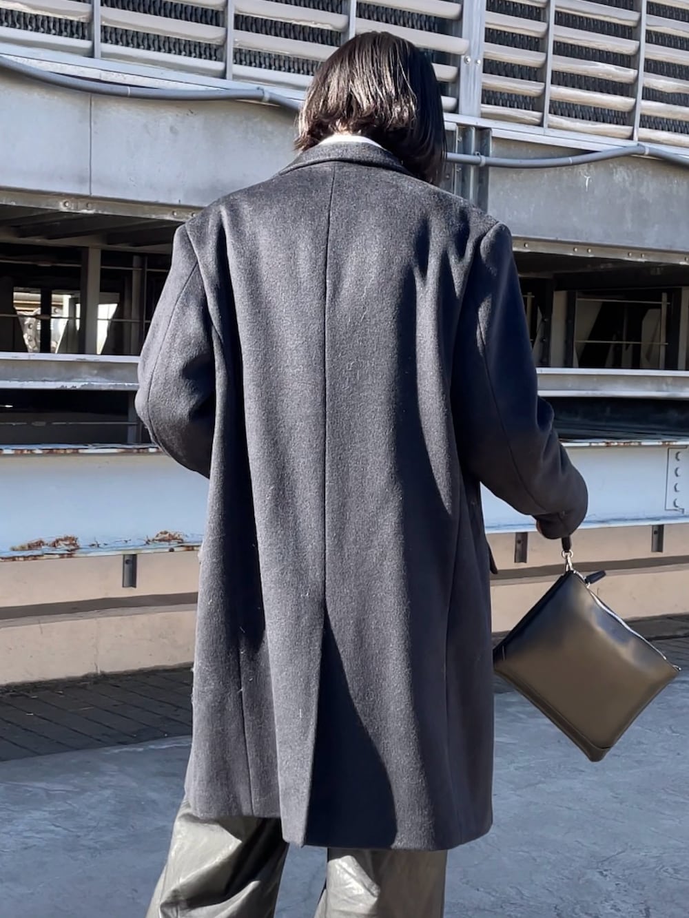 ブラック系のチェスターコート、ブラック系のショルダーバッグ、ブラック系のショルダーバッグを着用したレディースの冬コーディネートの4枚目の写真