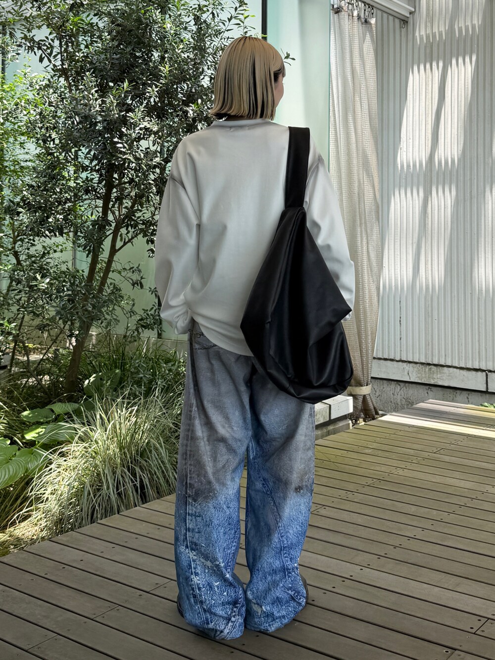 ホワイト系のTシャツ/カットソー、ブルー系のデニムパンツ、ブラック系のショルダーバッグを着用したレディースの夏コーディネートの4枚目の写真