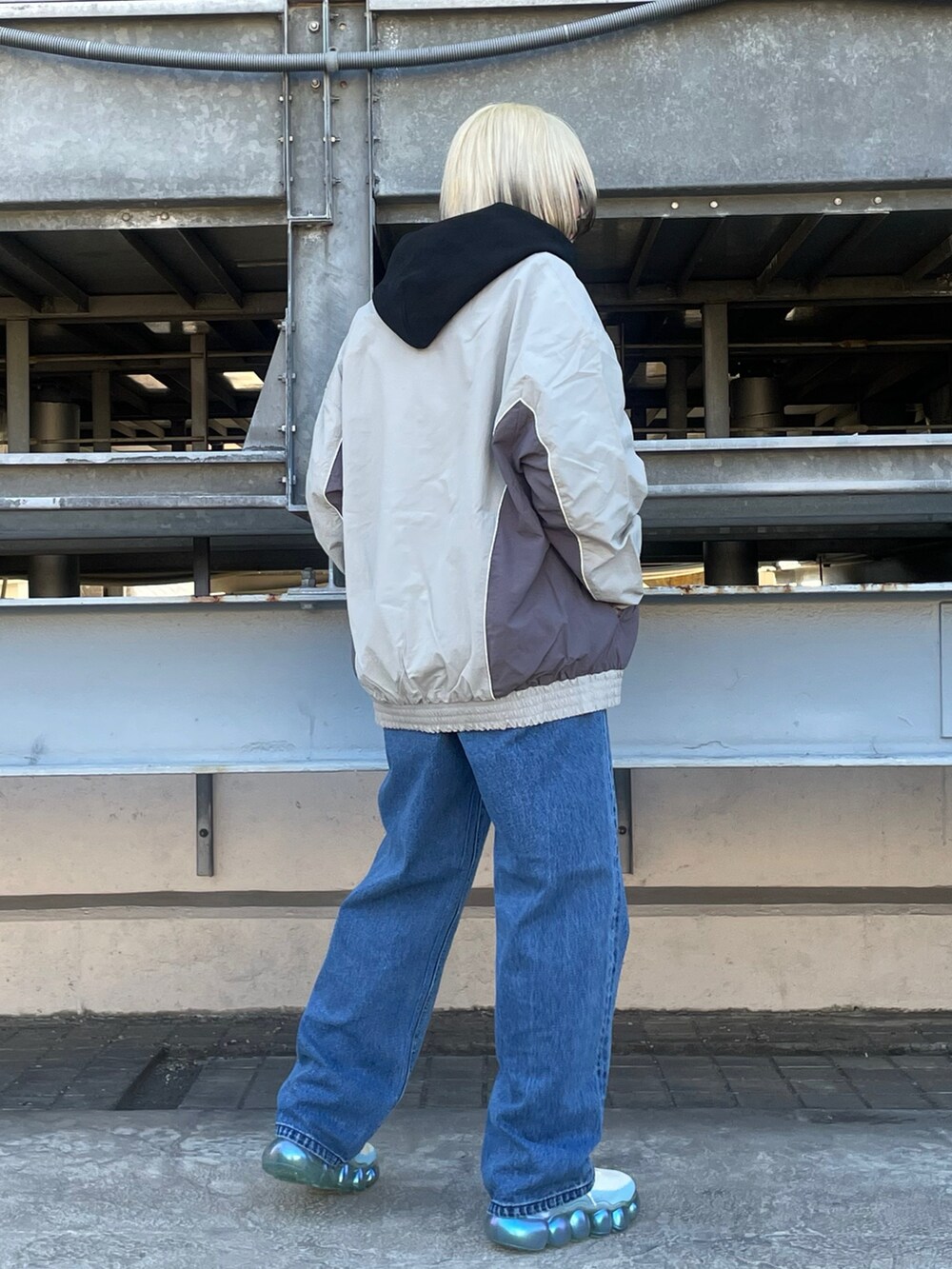 ブラック系のパーカー、グレー系のブルゾン、ブルー系のデニムパンツを着用したレディースの冬コーディネートの4枚目の写真